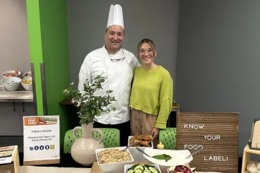 a girl poses with a chef at a BeWell event