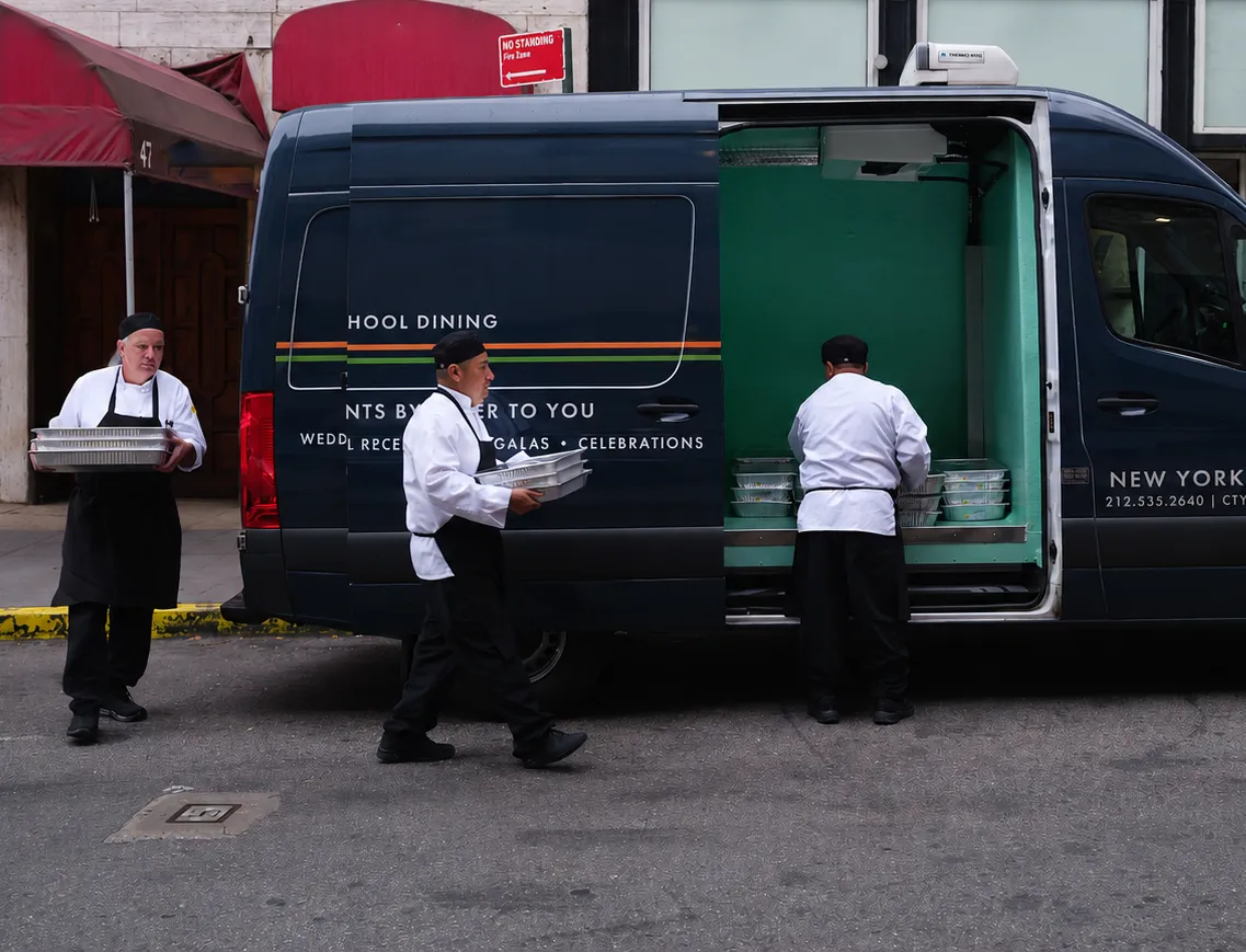 Chefs loading up sprinter van with food