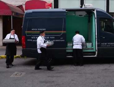 Chefs loading up sprinter van with food