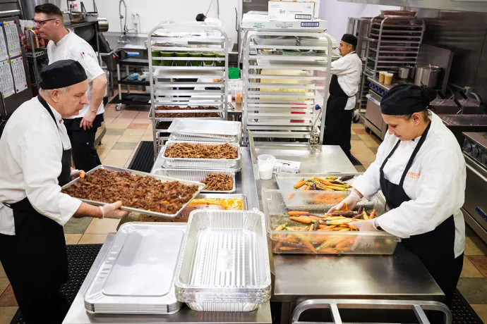 chefs prepare food in a busy commercial kitchen