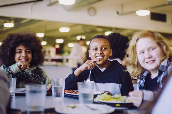 three boys eating school lunch